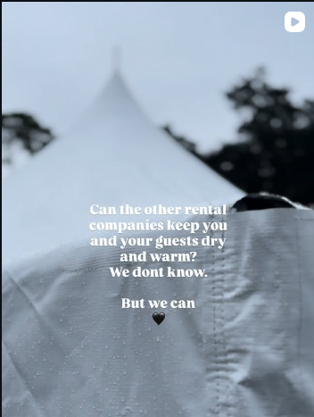 A white high-peak tent keeping guests dry at an outdoor event in the rain.